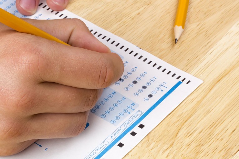 Student filling out answers to a test with a pencil.